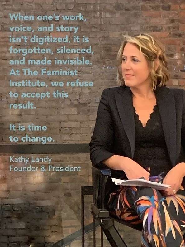 Kathy Landy, founder of the Feminist Institute, sits in a black chair, looking to her right. She has shoulder length dirty blonde hair, a black blazer and blouse, and colorful pants.