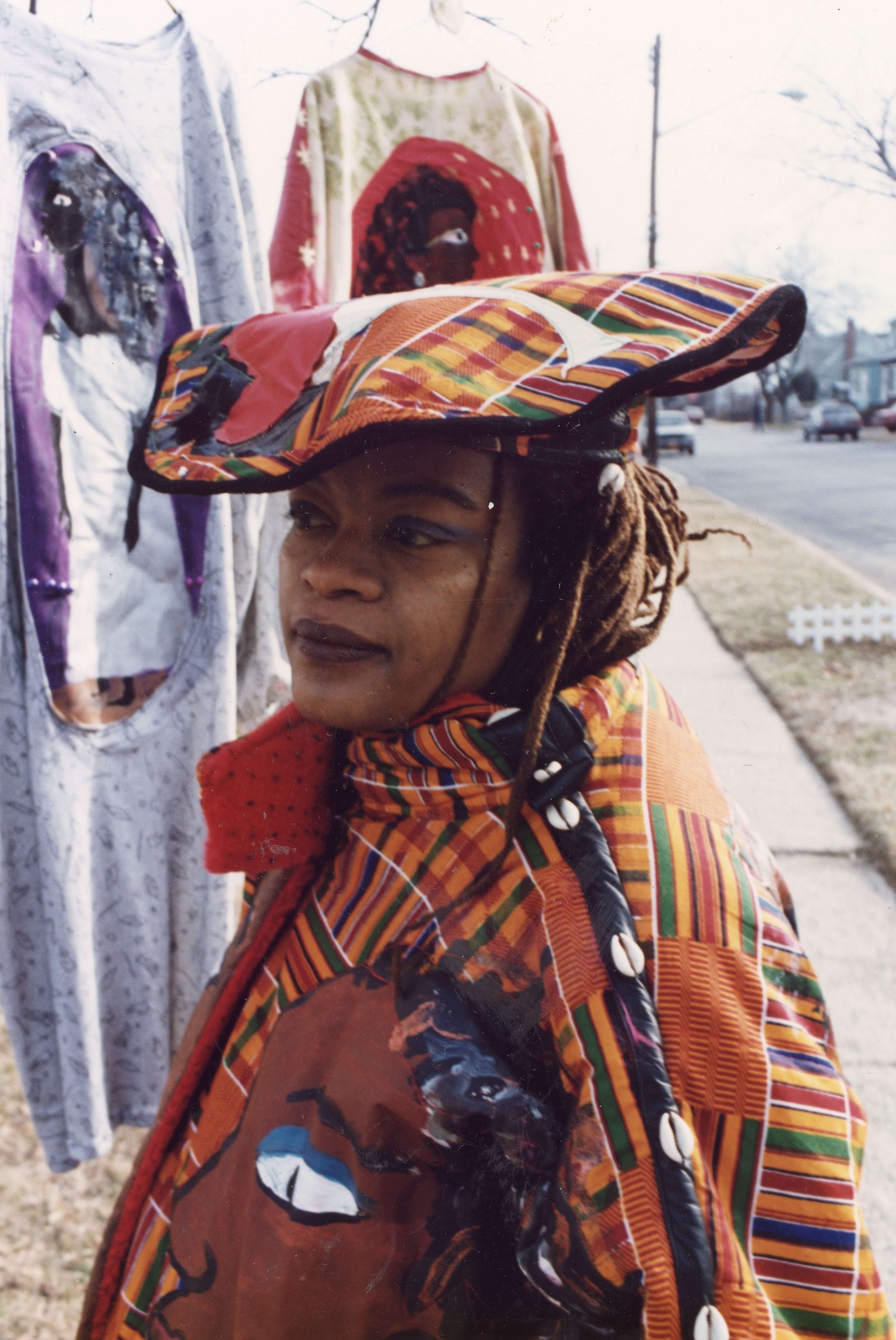 Dindga McCannon wearing her own designs. She has on a orange patterned hat and jacket.