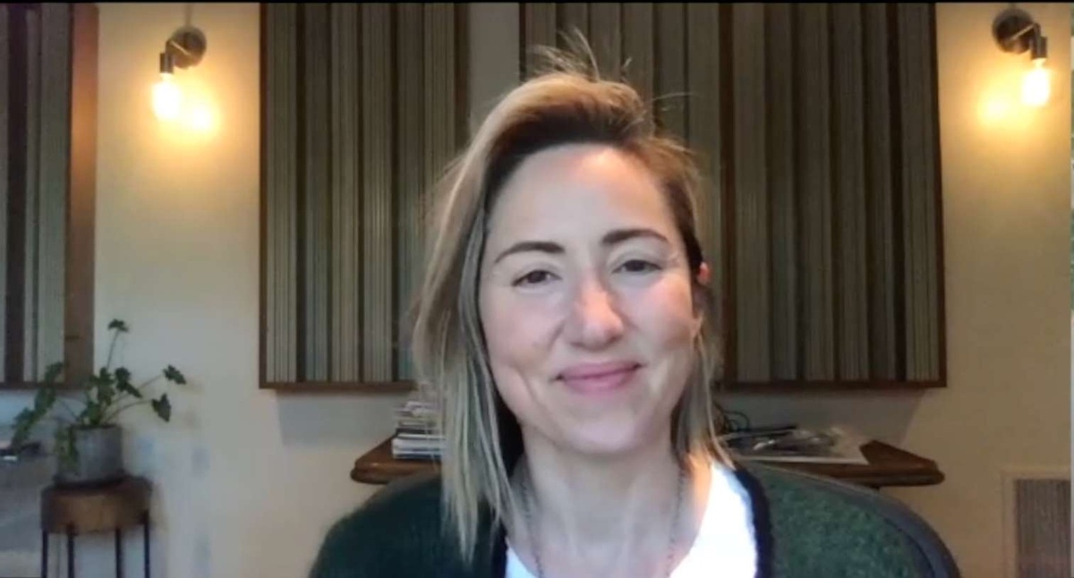 Picture of singer-songwriter KT Tunstall wearing a green sweater in front of a table and a houseplant