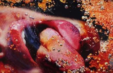 Photograph of Marilyn Minter, "Orange Crush. Smushed lips with orange texture.